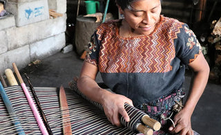 A woman weaving thread.
