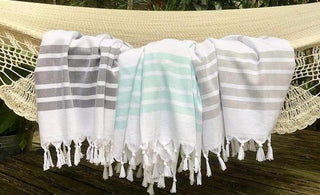 A group of white and grey striped towels on a hammock